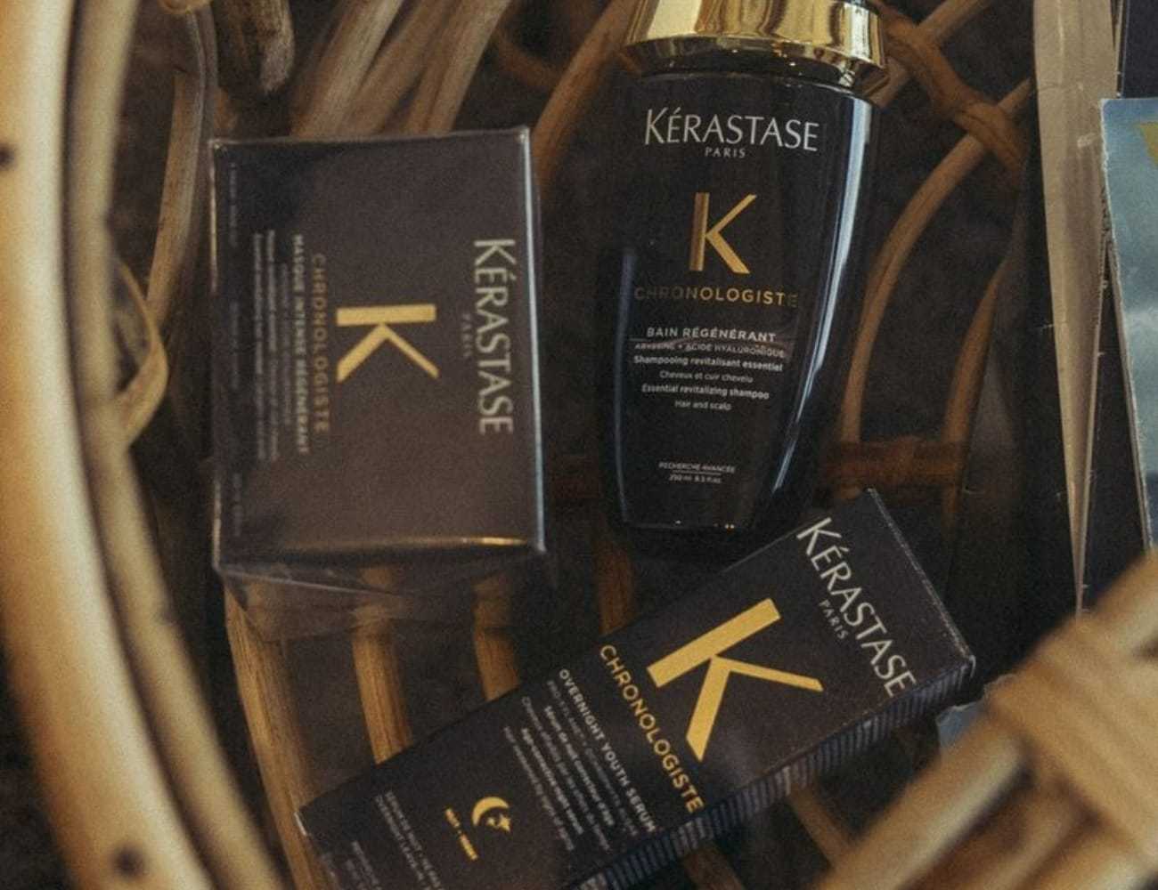Kérastase Chronologiste hair care products displayed in a basket on a wooden surface.