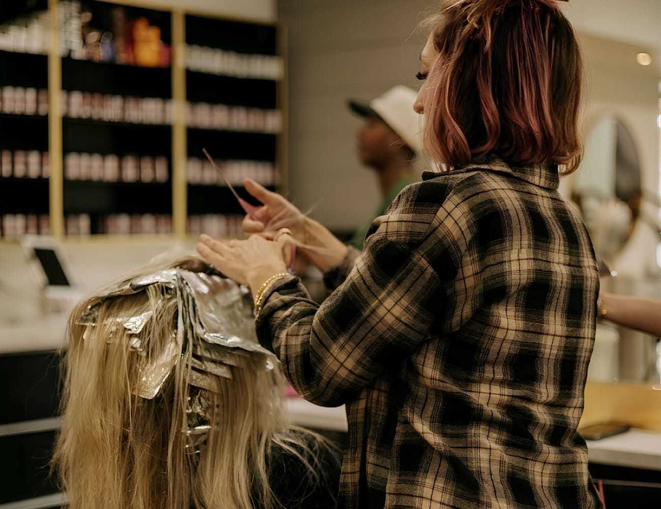 Hairdresser applying foil highlights in a salon.