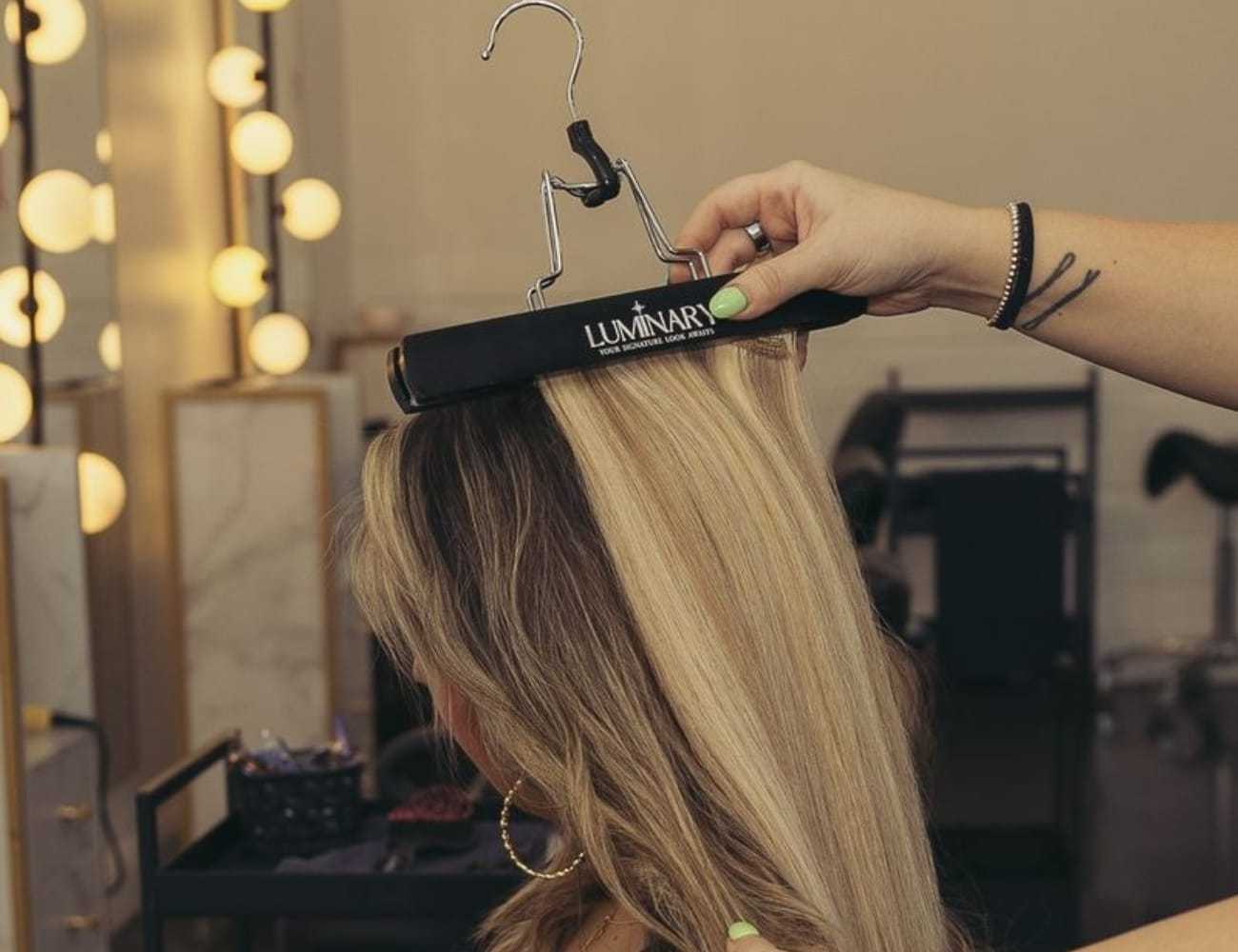 Hair color swatches shown against blonde hair in a salon setting.